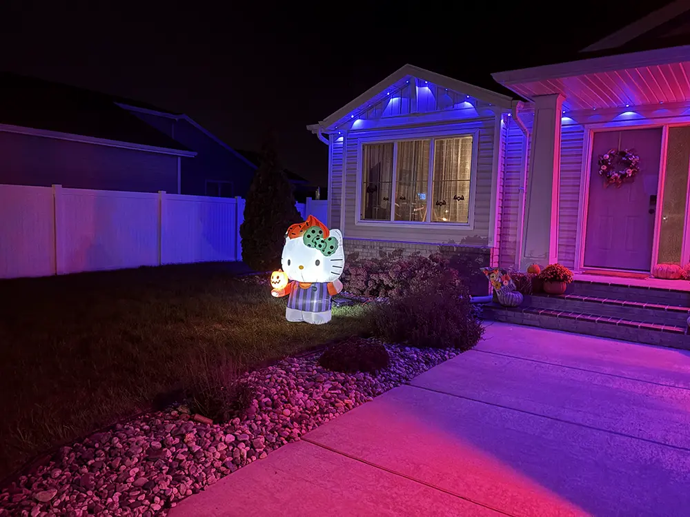Hello Kitty Halloween inflatable lit up on the lawn beside the house