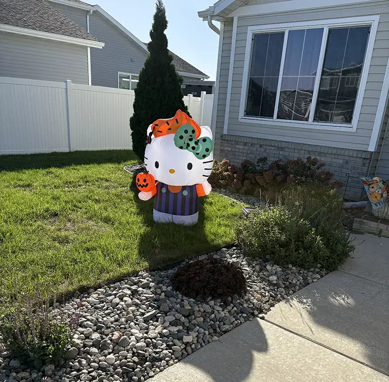 Hello Kitty Halloween inflatable standing on the lawn beside the front garden and walkway